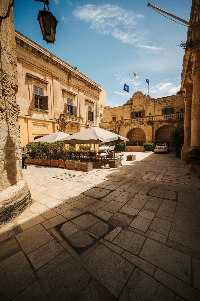 Honey limestone facades in a sunlit Mdina square